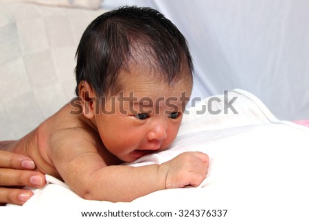 Naked newborn baby girl in face down position