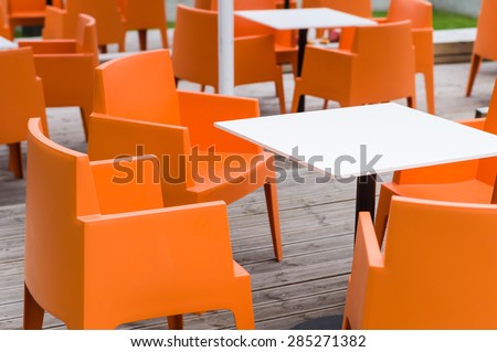 Modern furniture outdoor cafe terrace with orange chairs