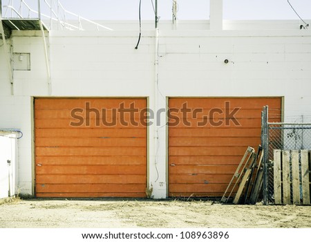 An old urban garage with bright orange doors