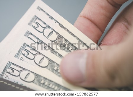 Person counting cash from their wallet