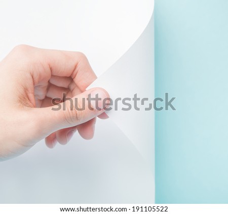 Person turning the white page revealing blue