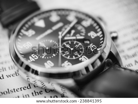 Luxury watch up close on a newspaper in black and white