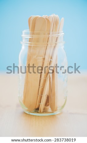 Tongue depressors in a mason jar up close