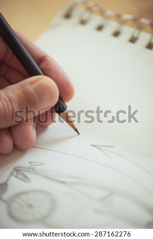 Designer drawing in a sketch pad - Split toned