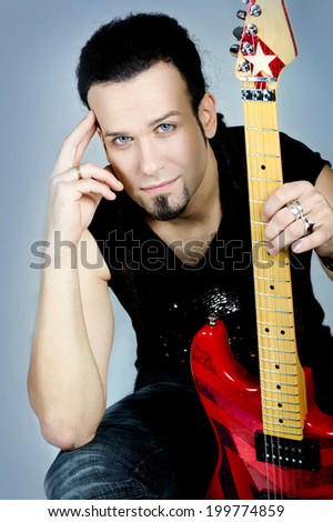 A portrait of a young guitarist , isolated on blue background