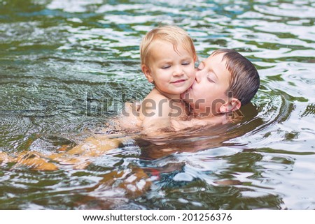 Siblings kissing in the pool