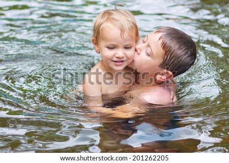 Siblings kissing in the pool