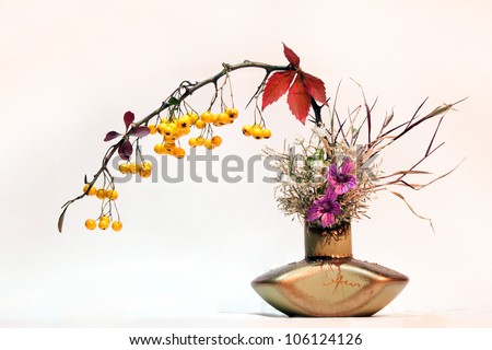 Isolated flower bucket ikebana style on white background with yellow vivid fruits
