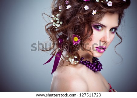 Young beautiful woman with flowers in her hair and bright artistic makeup