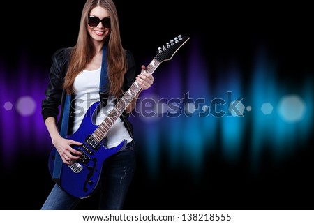 young beautiful woman with blue electric guitar wearing sunglasses