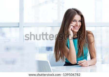 Young beauty smiling woman sitting in a  cafe and talking on the cellphone
