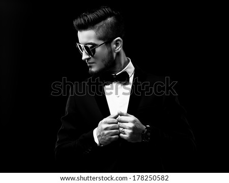 Portrait of handsome stylish man in elegant black suit and sunglasses