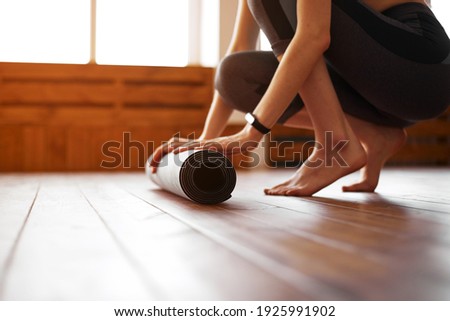Close-up of young woman with exercise mat preparing for sports training