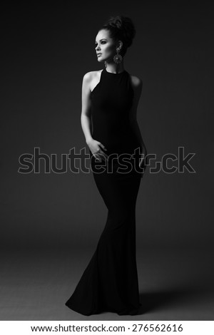 high fashion portrait of elegant woman in long black dress. Black and white studio shot