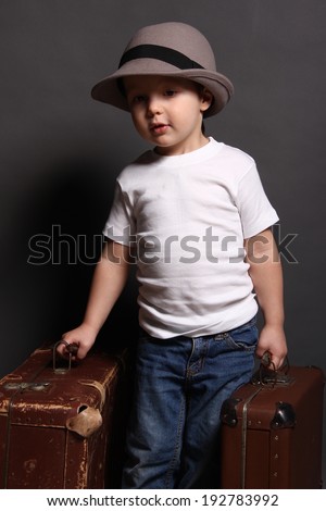 Little boy with big bag in hat