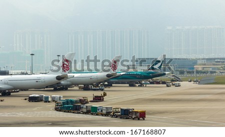 HONG KONG - OCT 09:  Trucks handling baggage at Hong Kong International Airport on Oct 9, 2013 in Hong Kong, China. About 90 airlines operate flights from HKIA to over 150 cities across the globe.