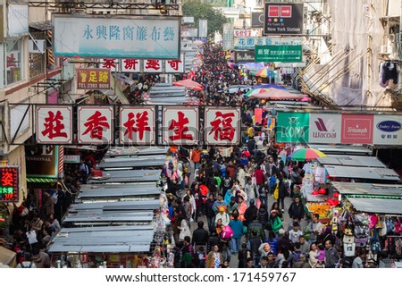 MONG KOK, HONG KONG - DEC 22, 2013: Crowded market stalls in Ladies\' Market on Tung Choi Street in Hong Kong. It stretches one-kilometre with over 100 stalls of clothing, accessories and souvenirs.