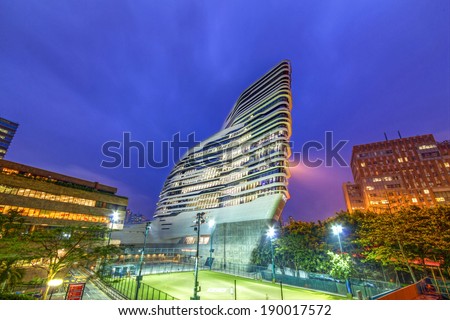 HONG KONG - APR 29, 2014: Night view of the Jockey Club Innovation Tower. It is home to Hong Kong Polytechnic University\'s School of Design. Designed by Pritzker-prize-winning architect Zaha Hadid
