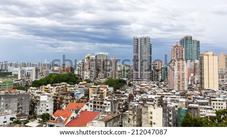 MACAU - JUNE 6, 2014: Macau packed houses and city skyline under the cloudy sky. Rich and poor stays close to each other in Macau, China.
