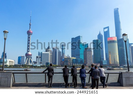 SHANGHAI, CHINA - OCT 24, 2014: A Group of Business People Looking at Shanghai Skyline. Shanghai is the largest Chinese city by population and the largest city proper by population in the world.