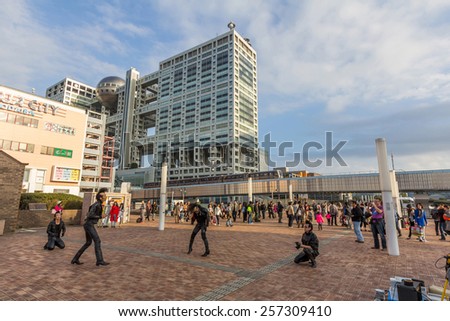 TOKYO, JAPAN - DEC 01, 2014: Unidentified men perform in front of Fuji Television Network Headquarters building in Odaiba, Tokyo, Japan. It is known for its unique architecture by Kenzo Tange