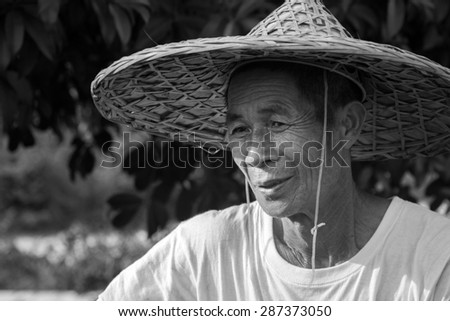 YANGSHUO, CHINA - MAY 01, 2015: A black and white portrait of an unidentified old farmer in Yangshuo, China. Agriculture is a vital industry in China, employing over 300 million farmers.