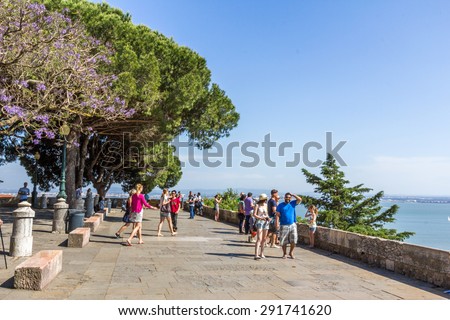 LISBON, PORTUGAL - MAY 24, 2015: Tourists walking inside Sao Jorge Castle in LIsbon, Portugal. It is a Moorish castle occupying a commanding hilltop overlooking Lisbon and Tagus River.