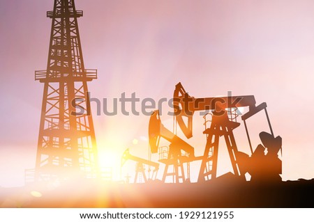 Darck silhoutte of oil rig and pumps during sunset