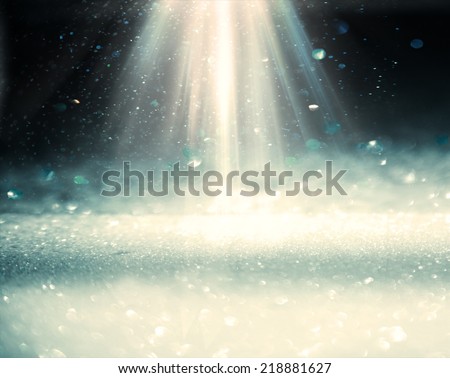 Light rays from top on the black blurren plane with bekeh lights