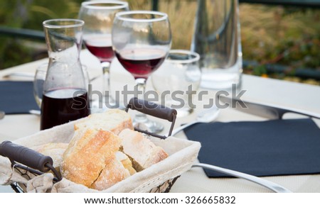 Carafe of red wine with two glasses on the table with dinner dishes.
