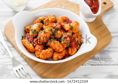 Foto Bild Gnocchi mit Tomatensauce und Parmigiano auf einem Teller.