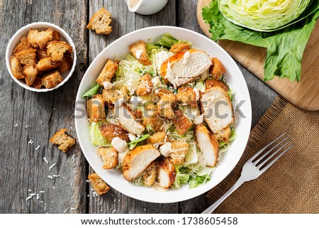 Classic caesar salad with grilled chicken fillet and parmesan cheese. top view