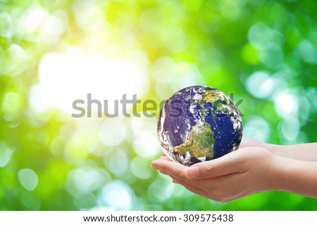 Safe world concept . Hand Holding world ball on  green bokeh.Copy Space on horizontal sheet.Elements of this image furnished by NASA