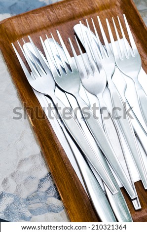 Forks and knives in wooden tray , spoon fork and knife on a wooden plate