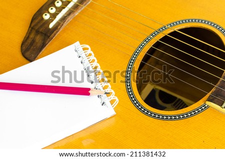 Notebook and pencil on guitar, Writing music , Write a Song