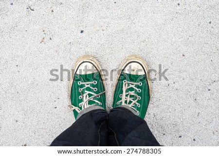 green Sneakers shoes walking on white Sand top view , Canvas shoes walking on white Sand