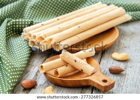 Tong Muan (a type of rolled wafer, a traditional dessert in Thailand) on wooden plate , rolled wafer