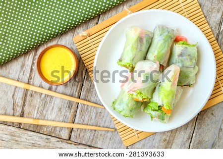 Salad roll vegetables with salad dressing in dish on wooden for Health