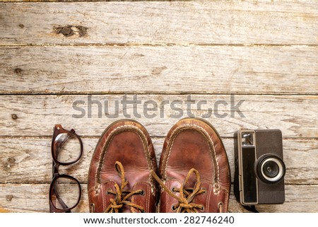 Camera and glasses and Leather shoe on a wooden , Still life travel on wooden