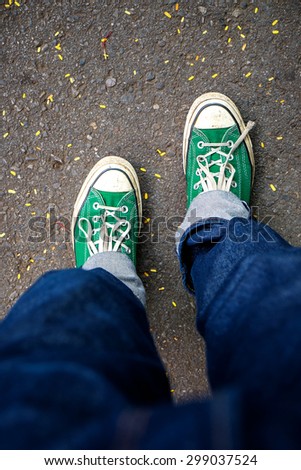 Green Sneakers shoes walking on concrete look top view , Canvas shoes on dirty road , Hister life