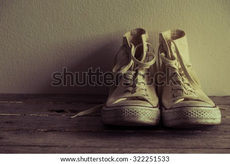 white sneakers on wooden in vintage look . youth culture and style.