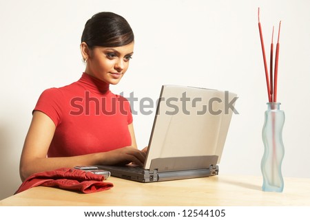 attractive business woman in red blouse working on laptop
