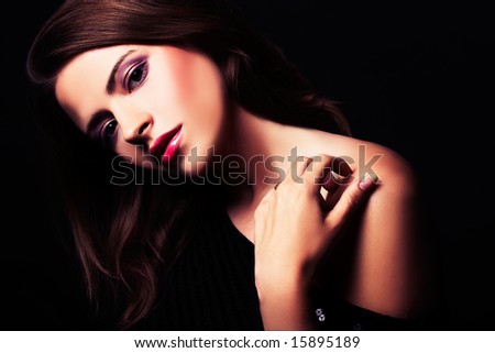 brunette girl posing in studio on dark background