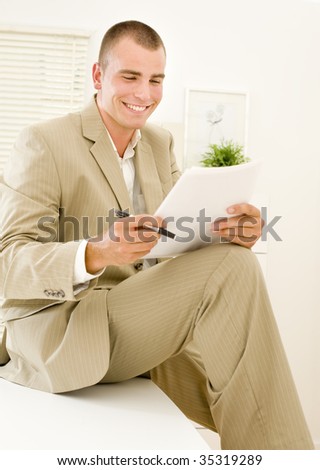 happy businessman reading reports on office table