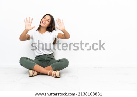 Teenager girl sitting on the floor counting ten with fingers Foto stock © 