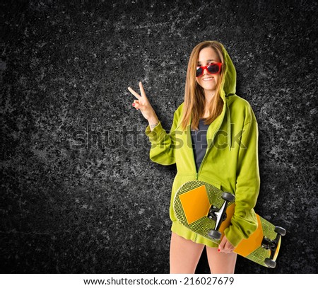 Young girl doing victory gesture over black background
