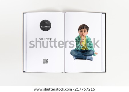 Kid doing silence gesture printed on book
