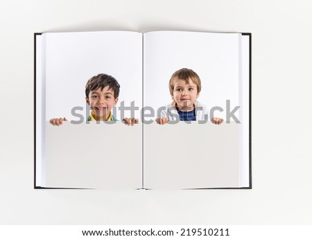 Kids holding empty placard printed on book