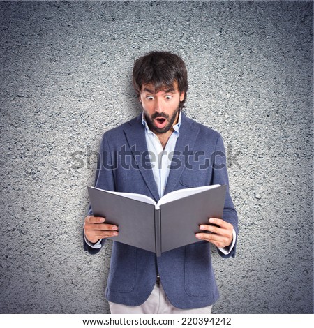 Surprised man reading a book over textured background