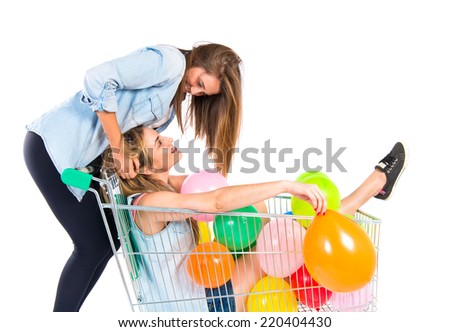 Friends playing with balloons and supermarket cart